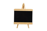 A small tabletop board sign with a blank black chalkboard surface and light wood trim stands on a matching wooden easel against a plain white background. Simple and minimalistic, it's ready for your notes or drawings.