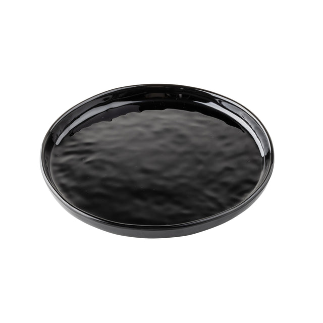 A round, black ceramic serving plate with a slightly raised edge and a glossy, textured surface is shown on a white background. The plate appears empty and has a simple, minimalist design ideal for modern table settings.