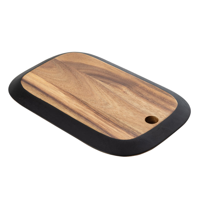 A rectangular serving board with rounded corners and a black edge border. Crafted from natural wood with a distinct grain pattern, this piece—part of the TableCraft Acacia Collection—features a small circular hole for hanging or easy handling.