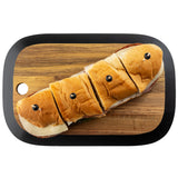 A sub sandwich cut into four pieces, each secured with a black olive on top, is placed on a TableCraft Acacia Collection rectangular serving board with rounded edges and a small hole in one corner, set against a white background.