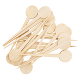 A pack of 100 TableCraft bamboo round picks with paddle-like tops and pointed ends, scattered on a white background. The visible wood grain highlights their natural, unfinished look.