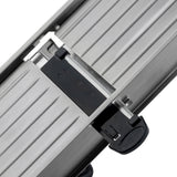 Close-up of a stainless steel mandoline sliding mechanism with parallel grooves, featuring a black plastic locking component with a circular grip and arrow symbol, suggesting it is part of a Mandoline Slicer Set or adjustable equipment.