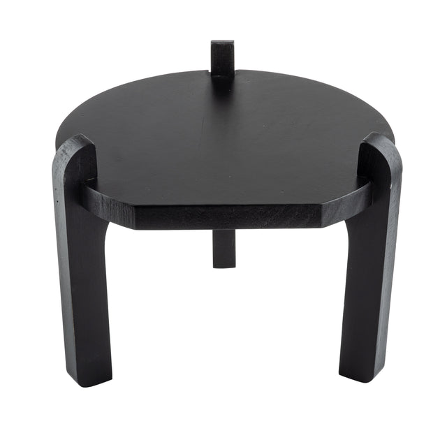 A modern, round, black painted wood stand with three thick, curved legs that extend above the tabletop for a bold, sculptural look. Perfect as a side table or TableCraft stand, it’s photographed against a white background.