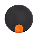 A round, flat, black plastic object with a small, semi-circular orange tab at the bottom edge, photographed against a white background. The item appears to be a decaf lid for a coffee carafe, possibly from TableCraft.