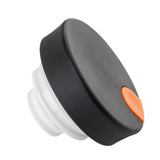 A black and white plastic coffee carafe lid with a wide, round top and an orange rectangular tab on the side, shown against a white background. The TableCraft cap features a grooved white thread for screwing onto a bottle.