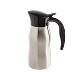 A TableCraft stainless steel thermal carafe with a curved body, black plastic lid, and ergonomic black handle, photographed on a plain white background. Ideal for serving coffee creamer, it features a spout and boasts a sleek, modern design.