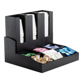 A black Coffee Condiment Organizer with three vertical cup/lid holders stores white disposable cups, while four compartments below neatly organize creamer pods, sweetener packets, and tea bags.