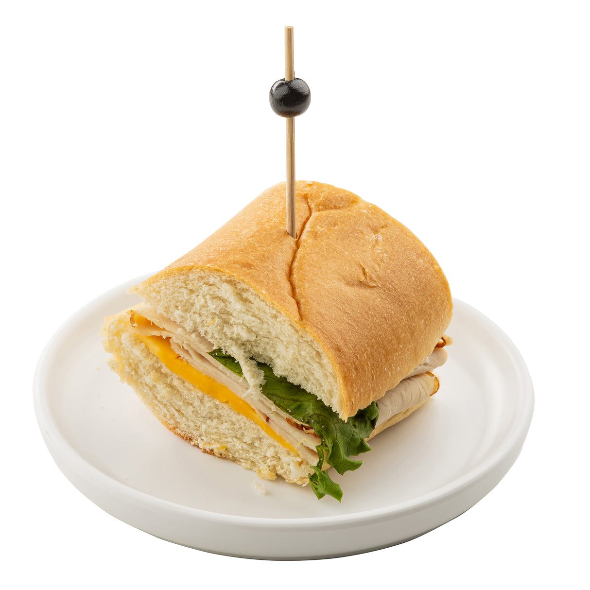 A sandwich on a white melamine Serving Plate from the Terra Collection, made with a soft hoagie roll, layered with lettuce, turkey slices, and cheddar cheese. A wooden skewer with a black olive on top holds the sandwich together. The background is plain white.