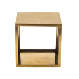 A square, open-sided metallic gold table or stool with a minimalist cube shape, this stainless steel riser features flat surfaces and sharp corners, plus an open center. The backdrop is plain white.