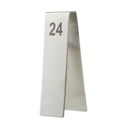 A silver, tent-shaped TableCraft stainless steel table number stand displays the number 24 in bold, black print near the top. The number tent is photographed against a plain white background.