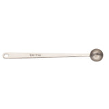 A stainless steel coffee scoop with a long handle and a round bowl. The handle is engraved with “5 ml / 1 tsp” and features a small hole at the end for hanging. The spoon is pictured on a white background.