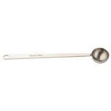 A stainless steel coffee scoop with a round bowl and a long handle. The handle is engraved with “10 ml / 2 tsp” and has a hole at the end for hanging. The spoon is clean and positioned on a white background.