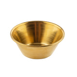 A small, round brass bowl with a wide rim and smooth, shiny surface, shown against a white background. The bowl’s golden color and gold PVD finish give it a polished and reflective appearance.