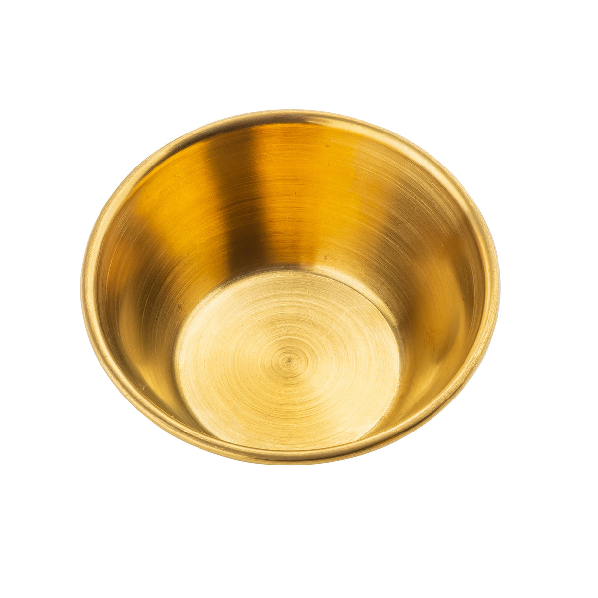 A shiny, empty brass bowl viewed from above. The bowl, resembling a stainless steel ramekin with a smooth, polished base, reflects light for a warm golden appearance. The background is plain white.