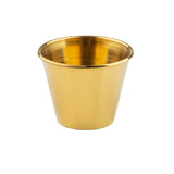 A shiny, metallic gold cup with a smooth surface and a wide rim that tapers down to a narrower base, this 2-1/2 oz ramekin features a stunning gold PVD finish. The cup is empty and set against a plain white background.