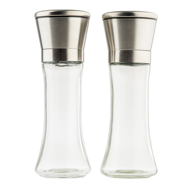 Two empty clear glass salt and pepper mills from TableCraft Products with stainless steel tops stand side by side on a white background. The Salt & Pepper Mill Set features a curved, elegant shape and modern, metallic lids, appearing clean and unused.