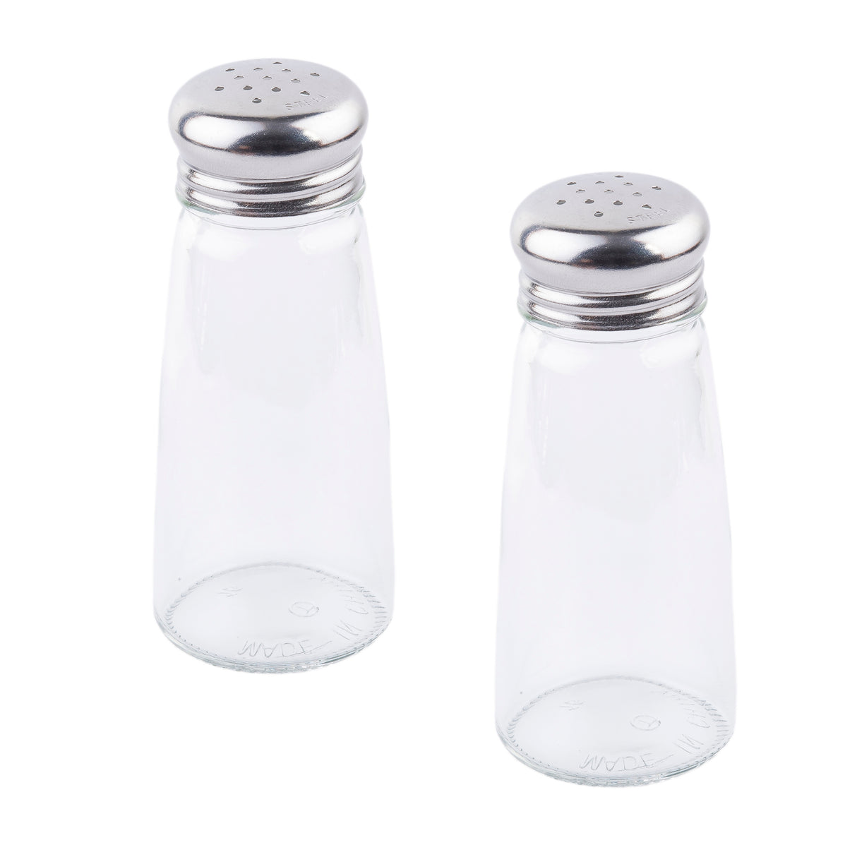 Two clear glass Salt/Pepper Shaker bottles with stainless steel tops sit upright on a white background, side by side with a slight gap. Their silver lids feature small dispensing holes and the shakers are empty.