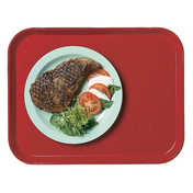 A green plate with grilled steak, sliced tomatoes, mozzarella, and spinach sits on a red Camlite Tray against a white background.