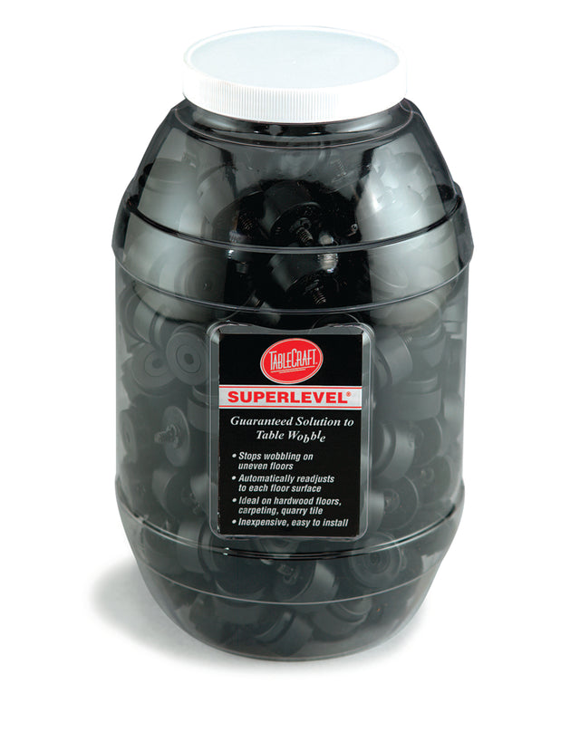 A large clear Cash & Carry Display Jar with a white lid, filled with black Superlevel table wobble stoppers. The label highlights their 500 lb. capacity and features like vibration stopping, easy installation, and reliable table glides.