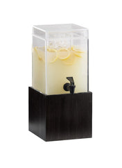 A clear, square 1-1/2 gallon beverage dispenser with ice and lemon slices floating in lemonade sits atop a tall, rectangular acrylic base. A black spigot is attached to the front for easy serving.