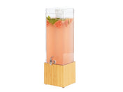 A tall, clear 3 gallon beverage dispenser filled with pink liquid, guava slices, and mint leaves sits on a square bamboo base. This BPA free dispenser features a small silver spigot for easy pouring. The background is plain white.