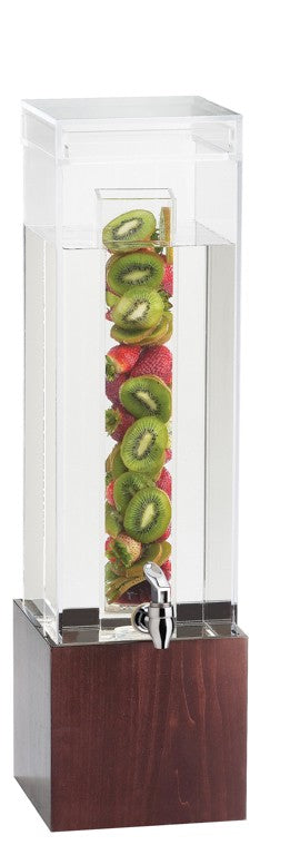 A tall, clear beverage dispenser with a BPA free infusion chamber and wooden base contains water. Sliced kiwis and strawberries infuse the drink, while a silver spigot at the bottom front allows for easy pouring.