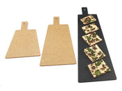 Three rectangular serving/display boards with handles are shown: two brown boards on the left and one large black NSF board on the right, which holds six rectangular slices of flatbread topped with mushrooms and greens.