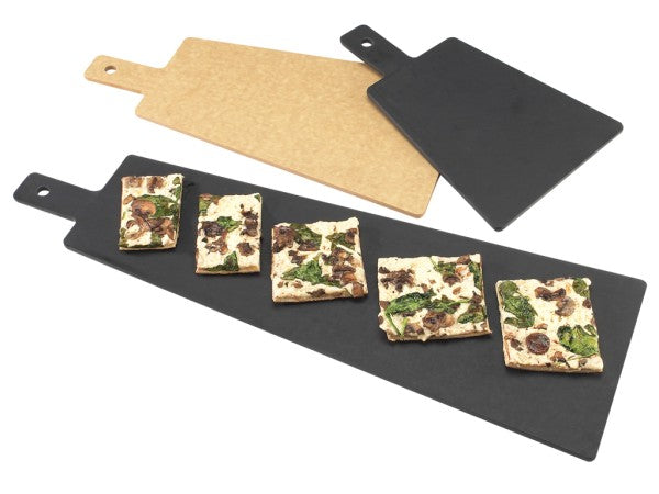 Two rectangular serving/display boards with handles—one black phenolic resin and one light brown—are shown. The black board, NSF certified, holds five flatbread pieces topped with mushrooms, spinach, and cheese; the brown board is empty above it.