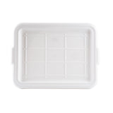 A rectangular, white Tote Box Cover lid is shown from above. The surface features a grid pattern with raised lines and a recessed central panel. The edges are slightly rounded, small handles are visible on the sides, and it is dishwasher safe.