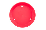 A round, bright red plastic platter basket viewed from above, with three small triangular cut-outs along the rim. The smooth, heat resistant surface sits against a plain white background.