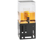 A transparent BPA Free beverage dispenser filled with orange liquid and lemon slices sits atop a modern black geometric metal stand. The dispenser features an infusion chamber and a front spigot for easy pouring.