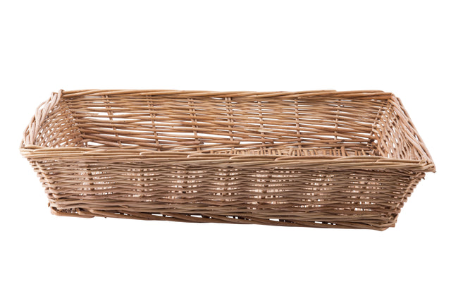 A rectangular handwoven basket with an open top, crafted from light brown reeds. The basket features slightly slanted sides and a flat base, with visible gaps between the woven strands. It is empty and sits on a white background.
