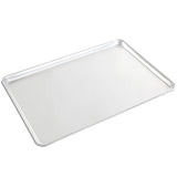 A plain, rectangular full size sheet pan made of heavy weight aluminum with slightly raised edges sits on a white background. Its smooth, reflective surface is angled to show the flat area and shallow sides.