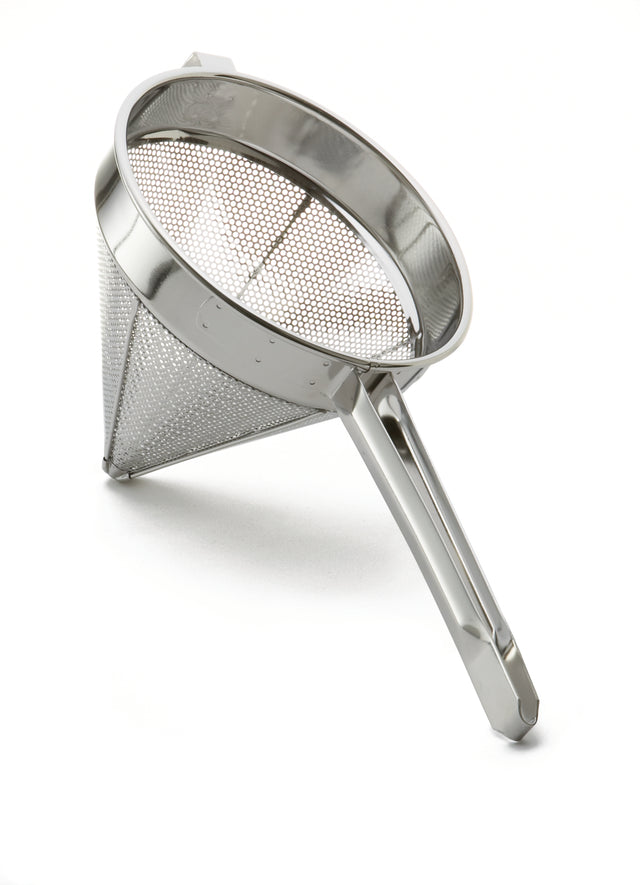 A heavy duty stainless steel China Cap Strainer with a long handle and fine perforations, angled to display its mesh side and sturdy construction, is placed on a white background. Ideal for sifting or draining in cooking.