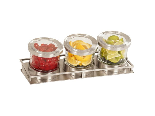 Three glass jars with silver lids sit in a stainless steel tray. The jars contain red cherries, yellow lemon wedges, and green lime slices—a clean and organized setup perfect as a cold condiment display for cocktail garnishes.