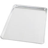 A rectangular, silver-colored bun sheet pan made from 19 gauge aluminum with slightly raised edges, shown on a white background. The smooth, reflective surface and rounded corners make it a chef approved choice for your kitchen.