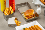 A fried chicken sandwich with lettuce on a bun sits in a stainless steel tray, next to containers of French fries. In the background are bottles of ketchup and mustard, a salt shaker, and mozzarella sticks on a white dish atop a light gray tabletop.