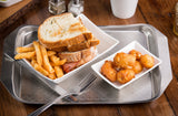 A stainless steel serving tray holds a plate with a stacked sandwich on toasted bread, crispy French fries, and golden-brown cheese curds. A fork rests nearby, with salt and pepper shakers and a white cup from the Better Burger Collection in the background.