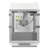 Front view of the Whiz Bang Popcorn Machine, a countertop popcorn machine featuring a stainless steel kettle in the center, clear glass door, stirring rod, control panel, warning labels on the back wall, stainless steel frame, and a white top.