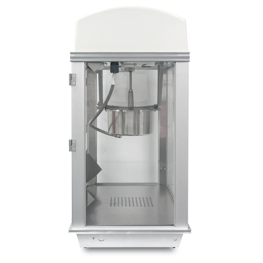A sleek and modern Whiz Bang Popcorn Machine in silver and white sits on a flat surface. Its clear glass front reveals an empty interior, while the stainless steel kettle hangs at the top inside this stylish countertop popcorn machine.