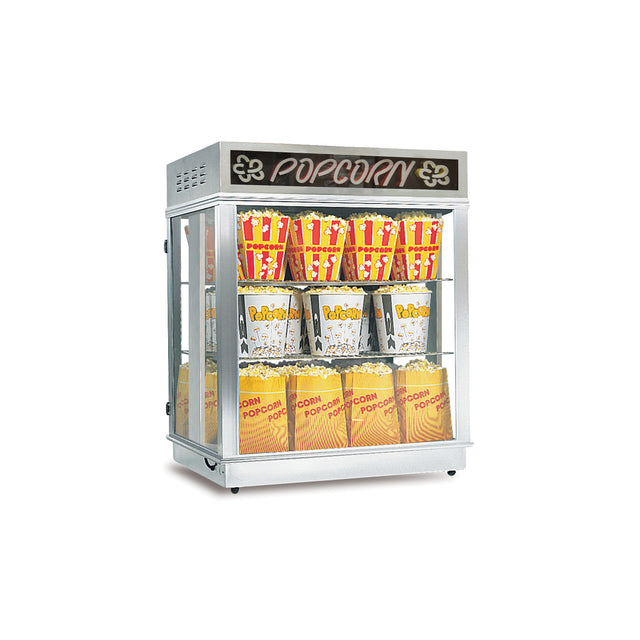 A silver popcorn shelf warmer with a glass front displays popcorn in striped and yellow bags on two shelves. The top has a “POPCORN” sign with yellow letters and popcorn illustrations. The unit is isolated on a white background.