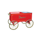 Red vintage-style popcorn cart by Gold Medal Products, featuring ornate gold "Popcorn" lettering, four large spoke wheels like a wagon, and a handle on one side. The cart has open compartments on top and is photographed against a white background.
