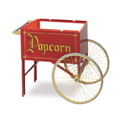 A vintage-style Gold Medal Products popcorn cart with a bold red exterior, large gold-rimmed wheels, ornate yellow "Popcorn" lettering, an open top, and a small handle at the back—perfect for classic snacking charm.