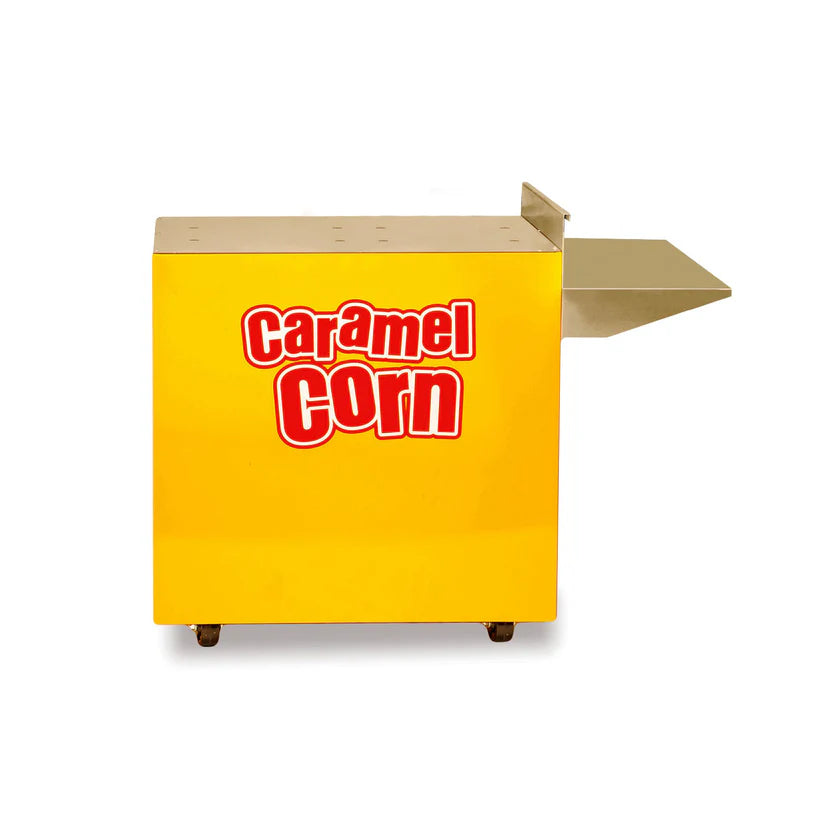 A yellow rectangular cart labeled Caramel Corn in bold red and white letters, featuring a flat metal shelf extending from the right side; this Gold Medal Products cart is on small black wheels and set against a white background.