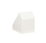 A plain, white, geometric object with a slanted roof-like top, resembling a minimalist house or building or even a modern flatware display, is centered against a white background. The object has clean lines and sharp angles, with no visible texture or detail.