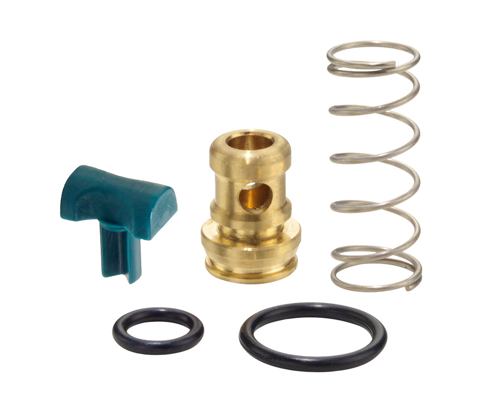 Five parts from a Krowne Repair Kit are arranged on a white background: a small green plastic lever, a brass cylindrical valve with two holes, a coiled silver metal spring, and two black rubber O-rings of different sizes.