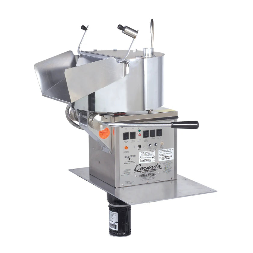 A commercial-grade electric popcorn machine with a metallic finish, Big Eye Electronic Heat Control, stainless steel popping kettle, angled metal chute, and black handle. The unit is labeled “Coronado Popping Unit” with various safety and instruction stickers.