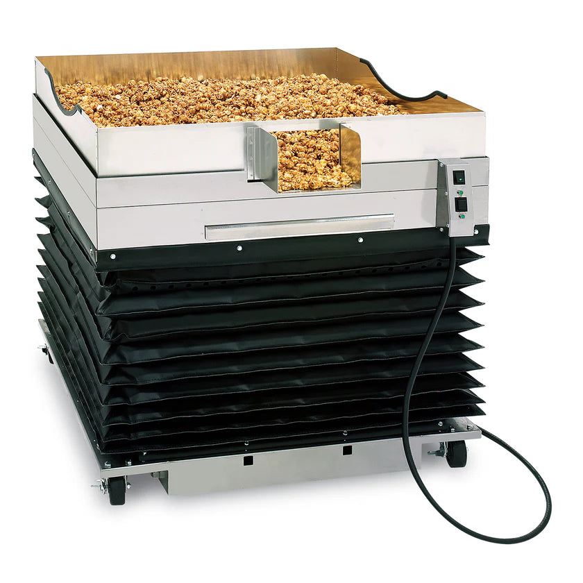 A commercial popcorn warmer with a stainless steel bin filled with popcorn on top, black accordion-style sides, control switches, and wheels for mobility features an adjustable height design, all set against a white background.