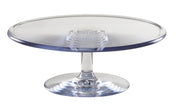 A clear polycarbonate cake stand with a round, flat top and a short, sturdy pedestal riser base. The smooth, reflective surface is empty and displayed against a plain white background.