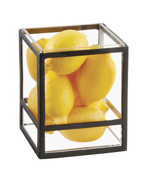 A glass and metal cube-shaped presentation display filled with bright yellow lemons, stacked together against a plain white background. The black metal frame and clear glass sides create a modern, geometric look perfect for any countertop riser.